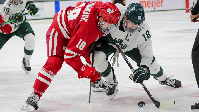 Owen Lindmark battling for a loose puck against Michigan State