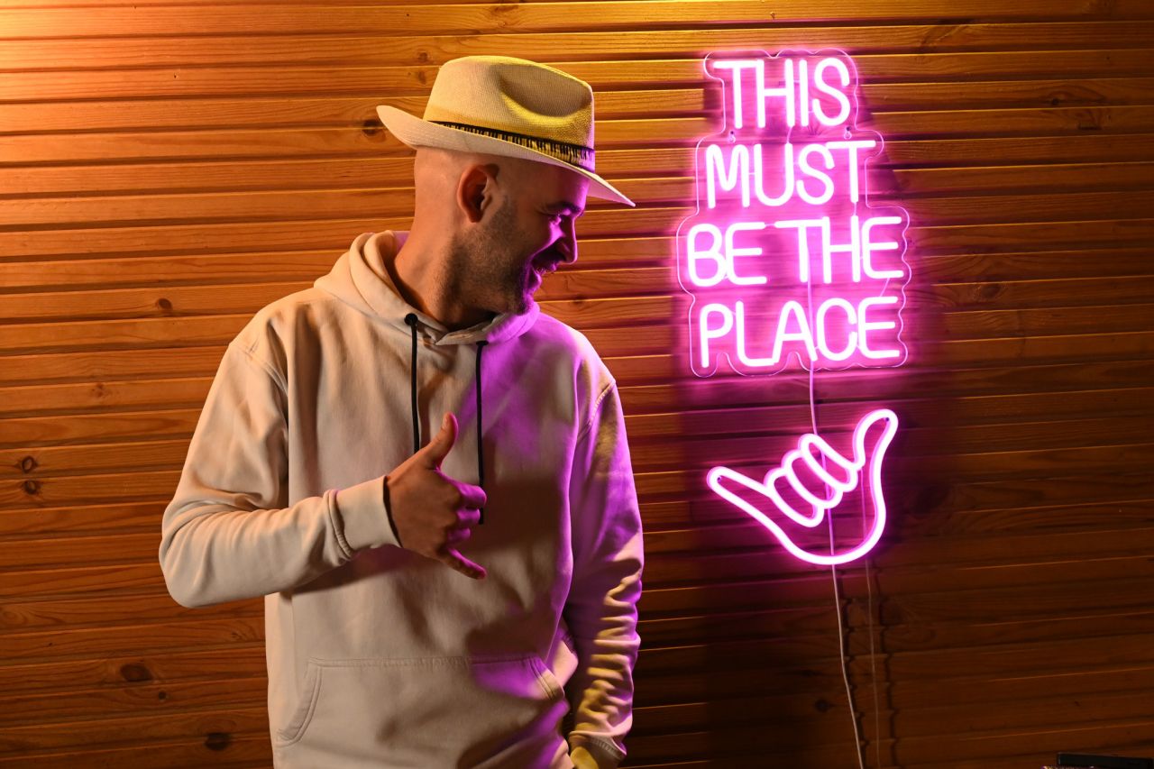 Murat Evgin poses for a photo by a neon sign on the wall at North Production Music Studio in Istanbul (Photo by Courtney Benedetto)