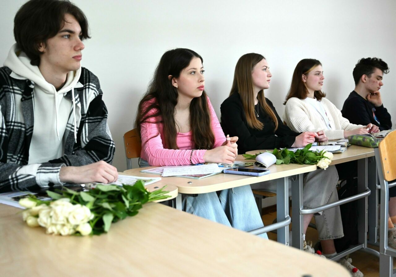 Five students seated at a long table.
