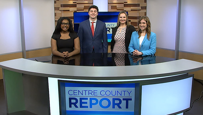 Four Centre County Report anchors standing behind the Centre County Report anchor desk