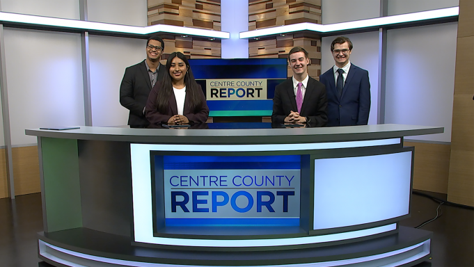 Four news anchors standing behind the Centre County Report News Desk