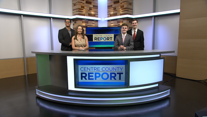 Four Centre County Report anchors standing behind the Centre County Report anchor desk