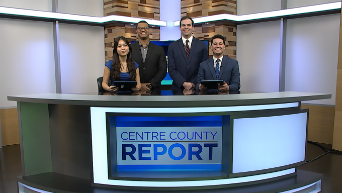 Four Centre County Report anchors standing behind the Centre County Report anchor desk