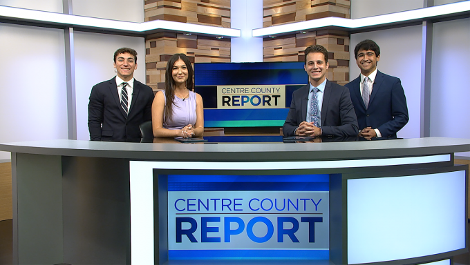 Four anchors standing behind the Centre County Report news desk