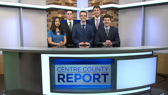 five anchors and reporters standing behind the Centre County Report anchor desk