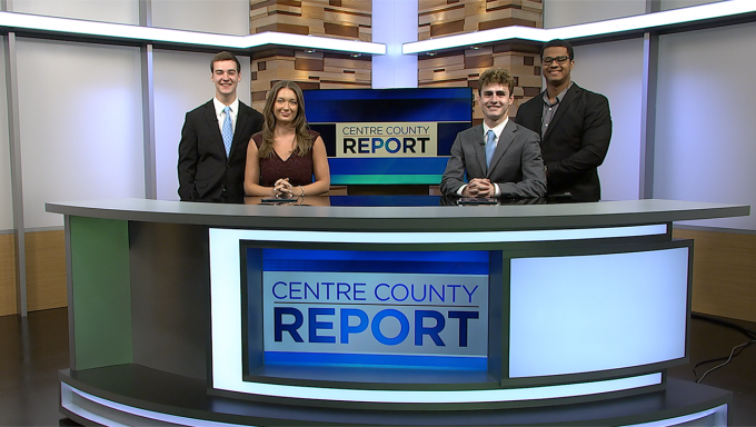 Four news anchors standing behind the Centre County Report news dek