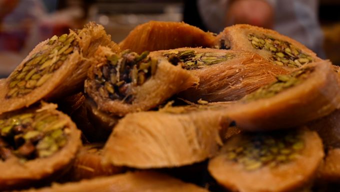 Baklava (A Turkish dessert of chopped nuts wrapped in filo pastry and syrup) is stacked high on a display plate in an Istanbul bakery.