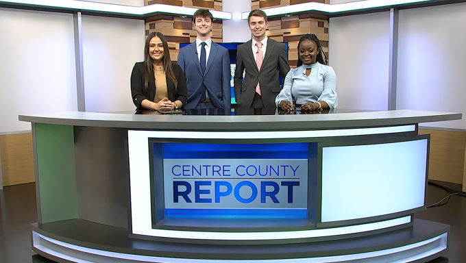 Four Centre County Report anchors standing behind the anchor desk