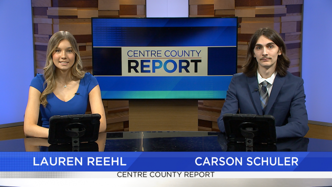 Two news anchors sitting at a news desk