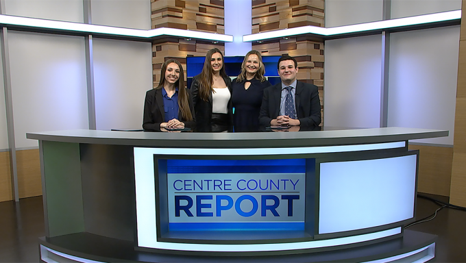 Four Centre County Report anchors standing behind the Centre County Report anchor deskt