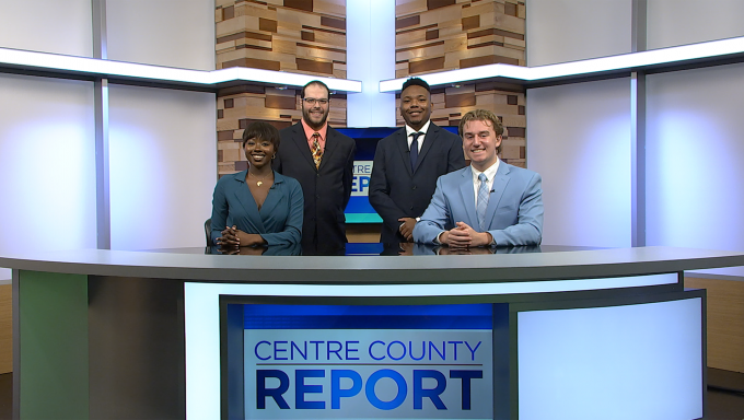 Three Centre County Report news anchors and a Centre County Report Meteorologist standing behind the Centre County Report news desk