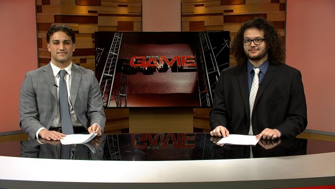 Student news anchors Jake Hernick and Jalen Salgado sitting and smiling at the desk.