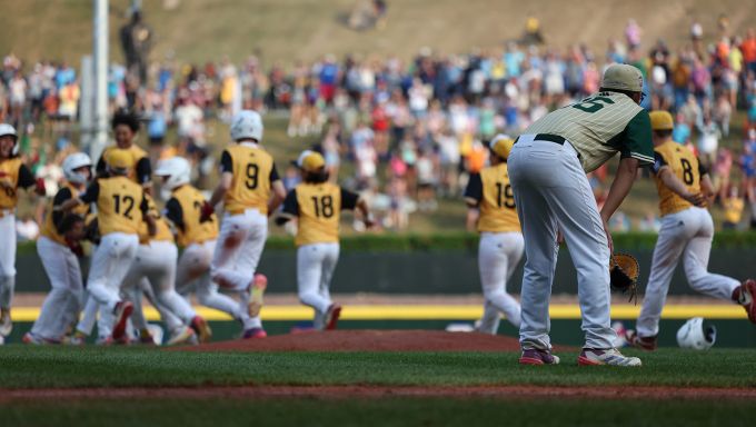 Baseball players celebrate  a group while one does not