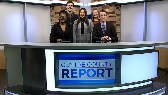 five centre county report anchors standing behind the centre county report desk