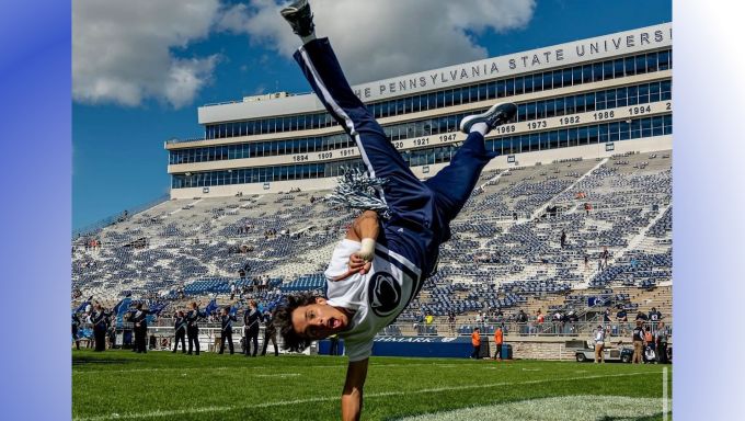 Airon is performing a one handed handstand on the football field