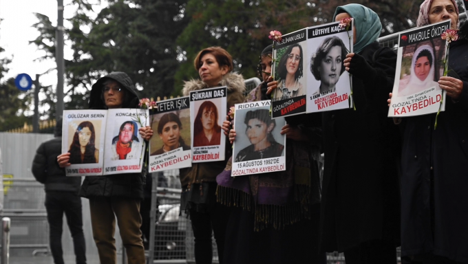 A group of. women stand in Galatasaray Square in Istanbul, Turkey holding photos of missing loved ones.