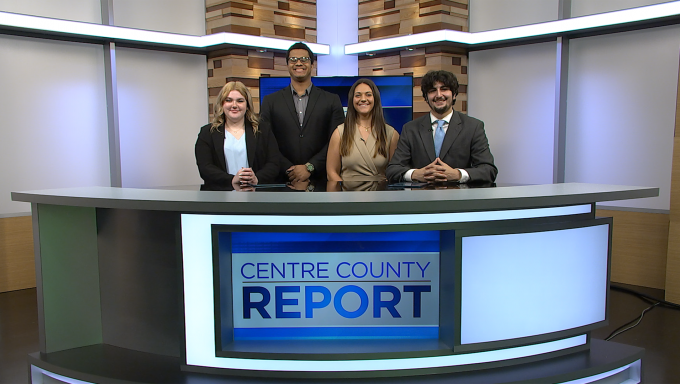 Four Centre County Report anchors standing behind the Centre County Report anchor desk