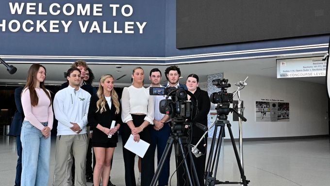 Students in Comm 400 look into a set of lights and cameras wrapping up the filming of an episode of In The Game at Pegula Ice Arena.