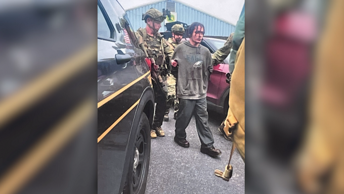 Photo of prison escapee Danelo Cavalcante, seen being escorted by Pennsylvania State Police following his capture Wednesday, wearing a Philadelphia Eagles Sweatshrt.