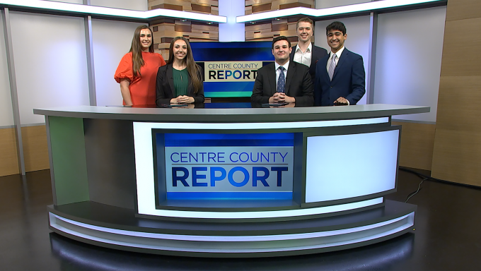 Five news anchors for Centre County Report standing behind a news desk