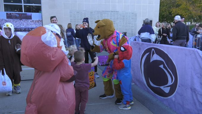 Nittany Lion giving out candy to trick or treaters