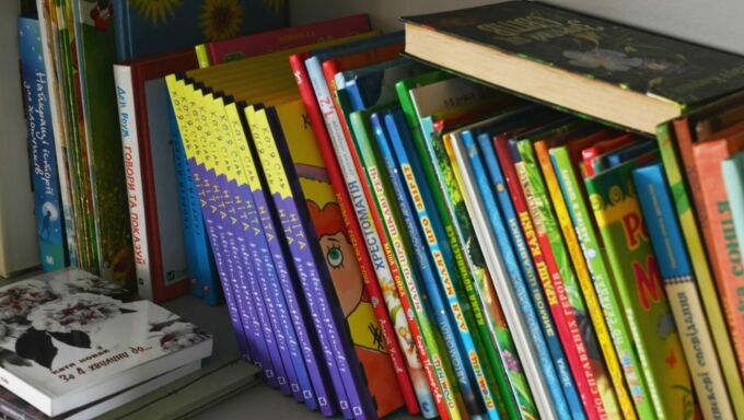 A stack of children's books on a bookshelf