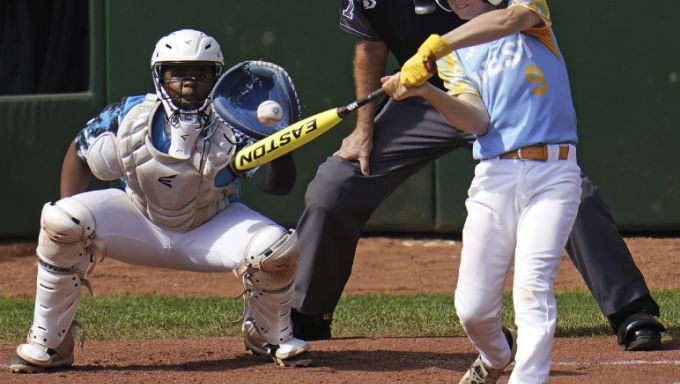 A Little League hitter takes a swing at a pitch