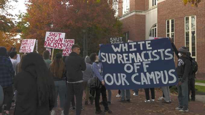 Protesters hold banner outside Thomas Building