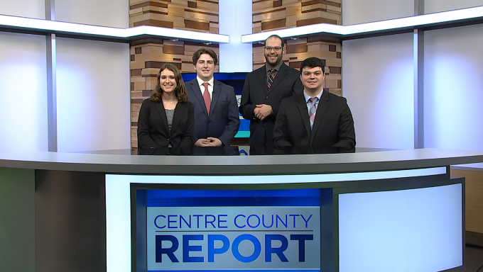 Four Centre County Report anchors standing behind the Centre County Report anchor desk