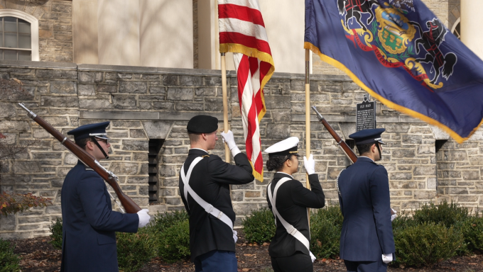 Penn State members of armed services carry the American and Pennsylvanian flags at the Veterans Day ceremony held at old main.