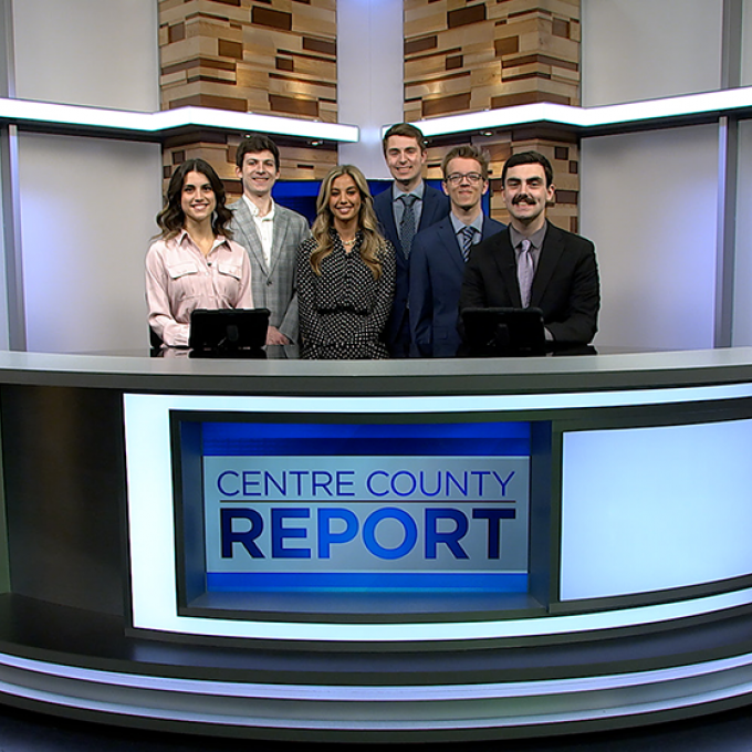 Six Centre County Report anchors and reporters standing behind the Centre County Report anchor desk