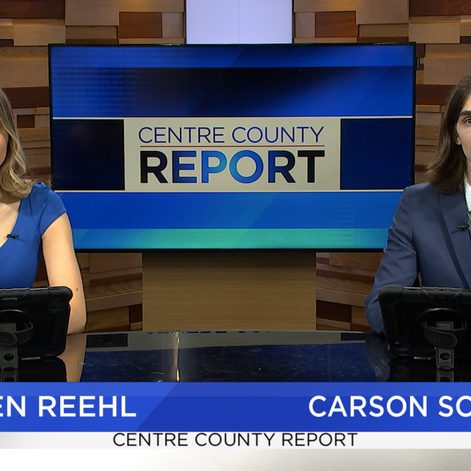 Two news anchors sitting at a news desk