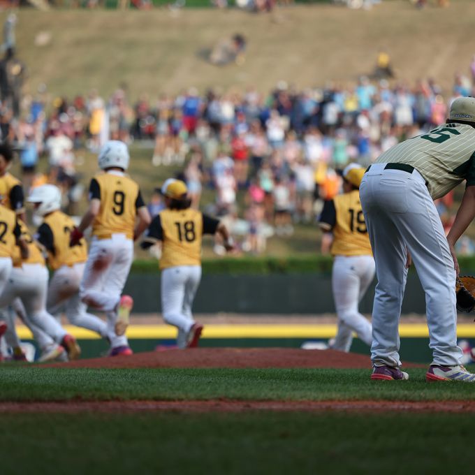 Baseball players celebrate  a group while one does not