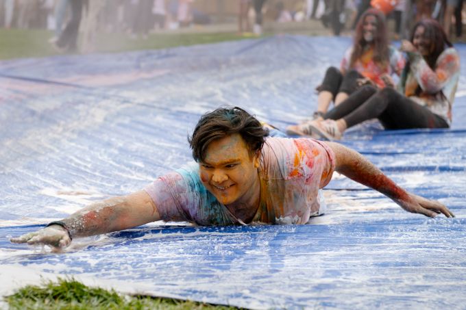 Student sliding on powdered blue tarp
