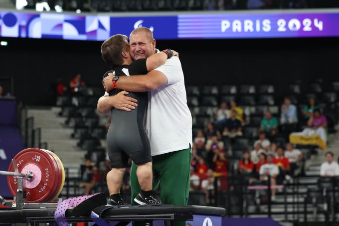 A hug between a lifter and his coach