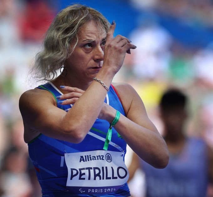 A blondhaired woman points toward the sky