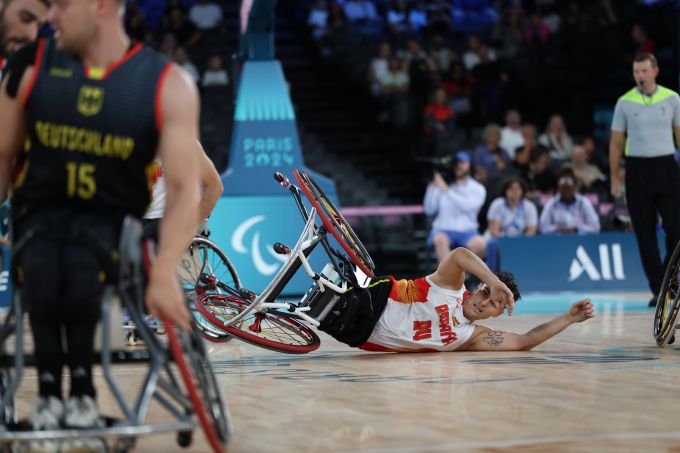 A man in a wheelchair falls on a floor