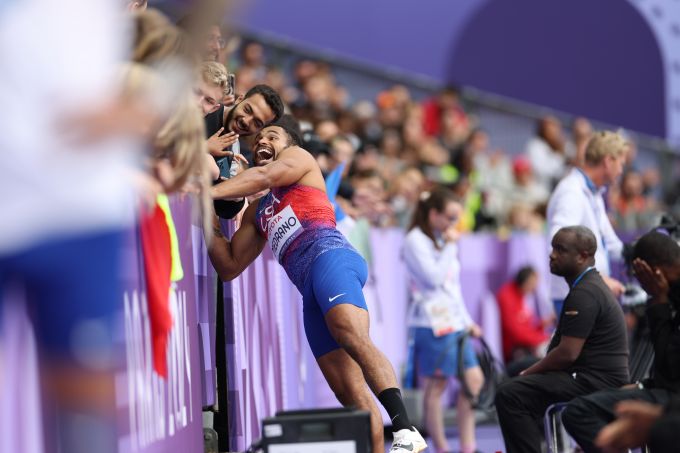 A runner mugs with a fan in the stands