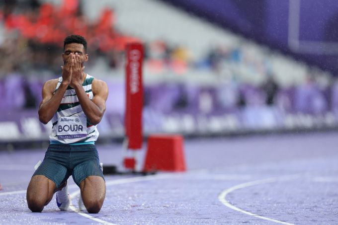 A man hits his knees, hands over face, to celebrate