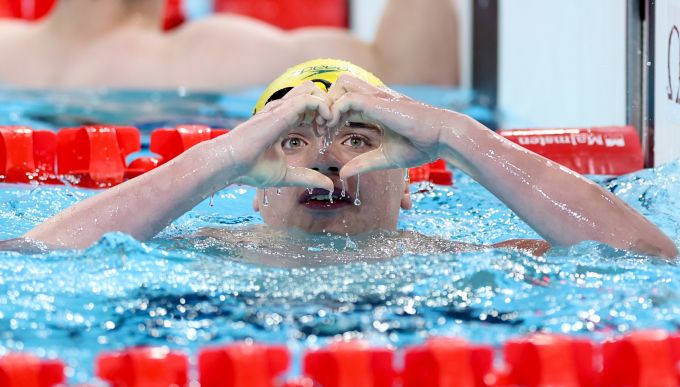 A swimmer makes a heart sign with his hands