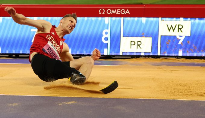 A long jumper lands in the sand