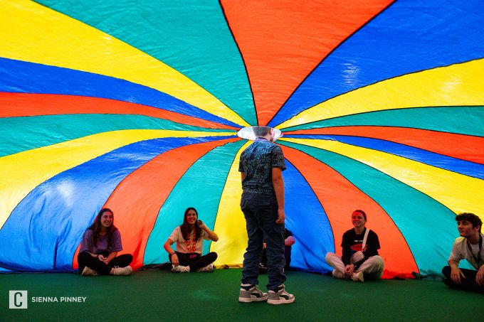 Man with his head through a multicolored parachute