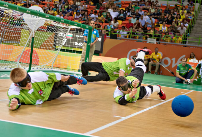 Diving athletes on a floor to block a ball