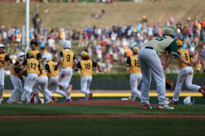 Baseball players celebrate  a group while one does not